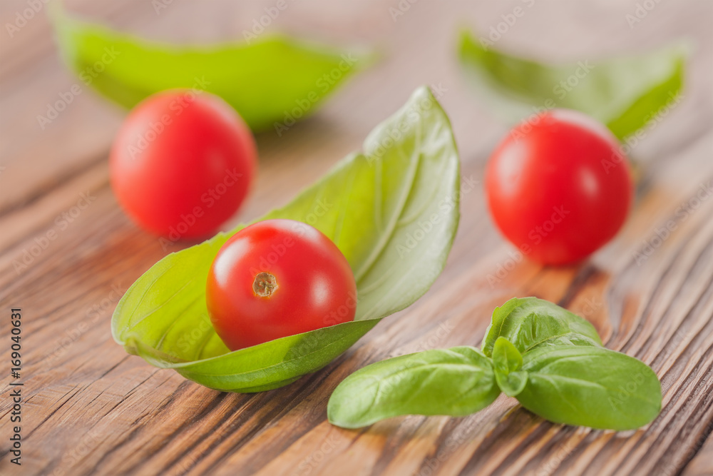 cherry tomato with basil on a wooden background cherry tomato with basil on a wooden background