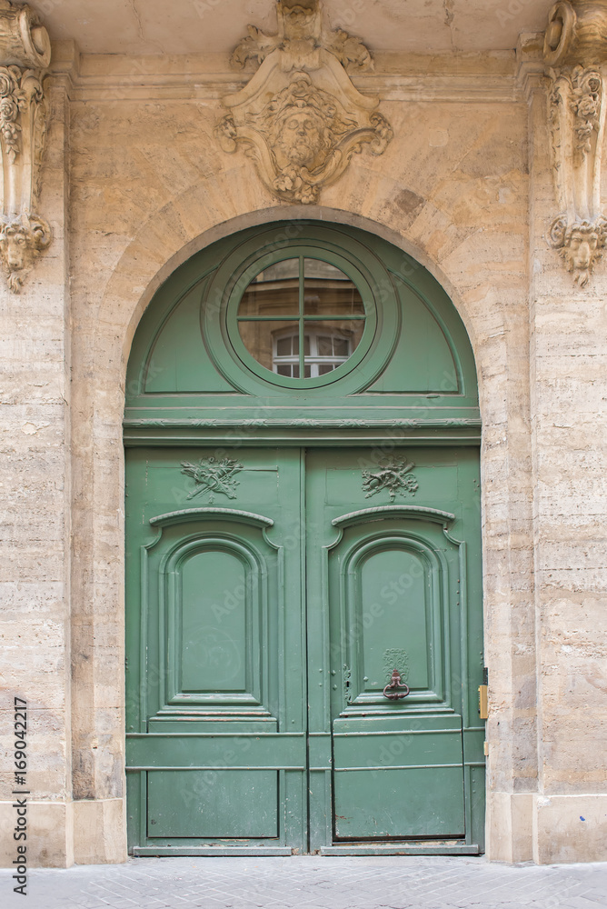     Paris, beautiful wooden green door, girder with sculptures 