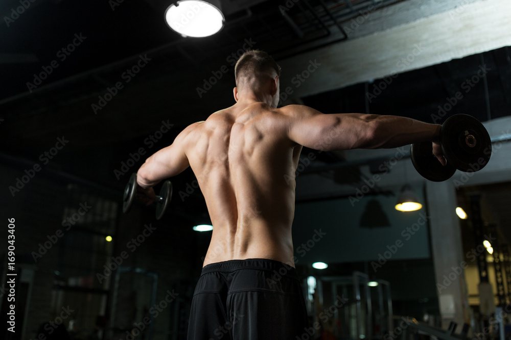 close up of man with dumbbells exercising in gym close up of man with dumbbells exercising in gym