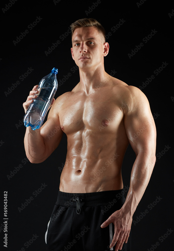 young man or bodybuilder with bottle of water young man or bodybuilder with bottle of water