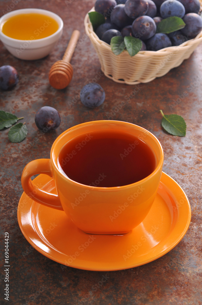 A cup of tea and plum on the table A cup of tea and plum on the table