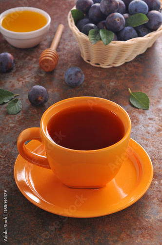 A cup of tea and plum on the table