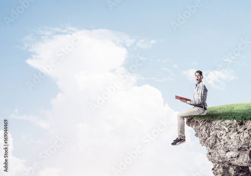 Student guy with book in hands preparing for exam