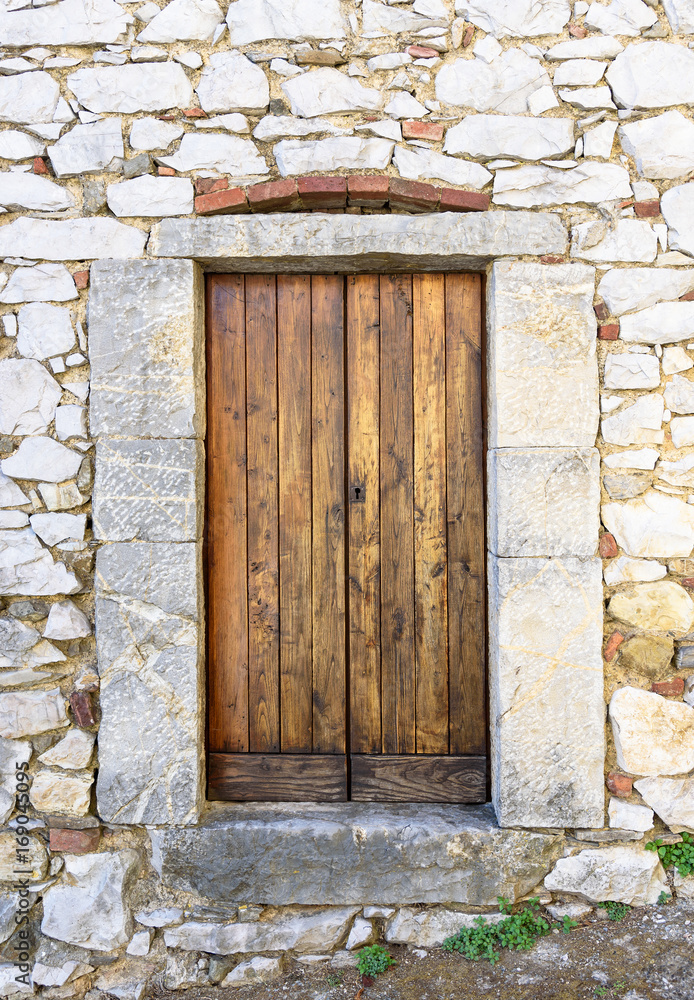 Fototapeta premium old wooden door on stone wall