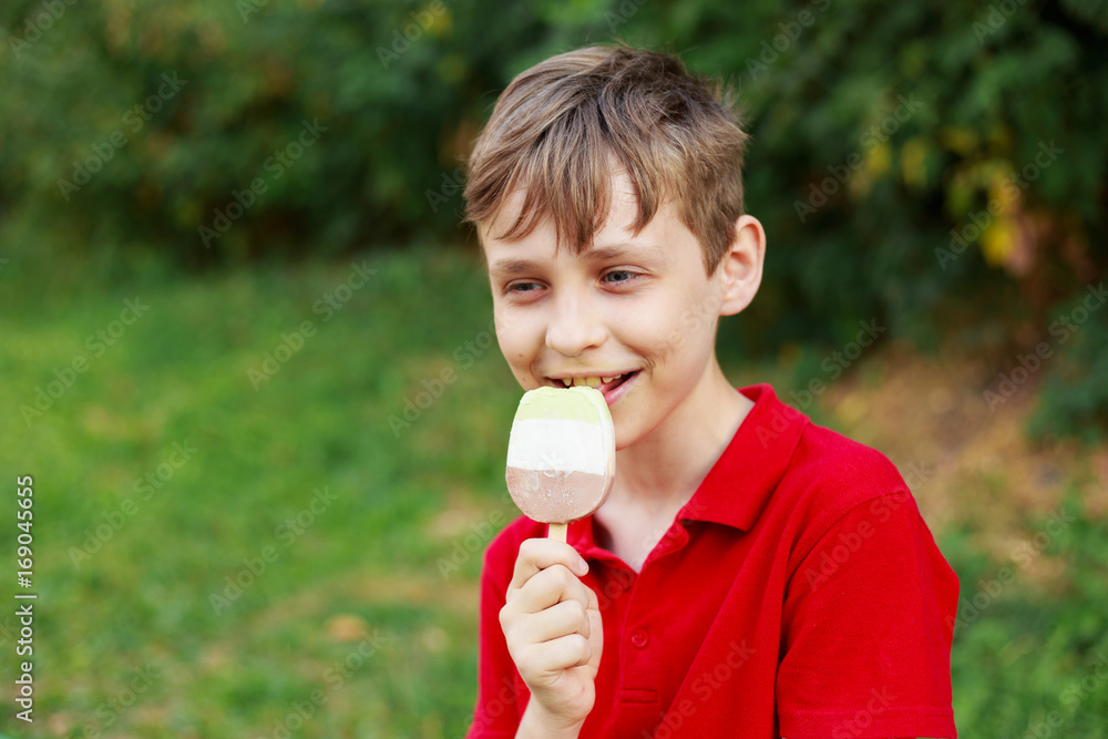 Smiling boy enjoys eating ice-cream. Childhood, family, happiness, people, sweets concept Smiling boy enjoys eating ice-cream. Childhood, family, happiness, people, sweets concept