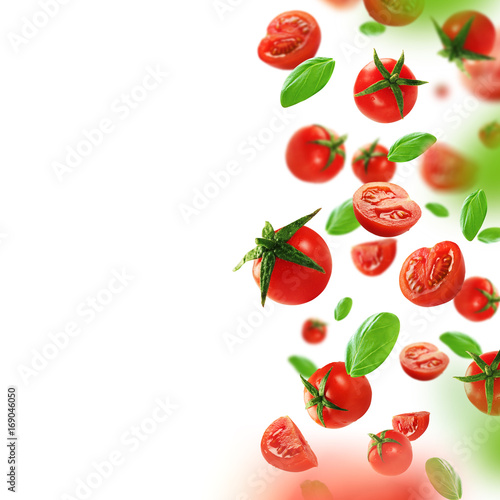 Cherry tomatoes and leaves falling from the air
