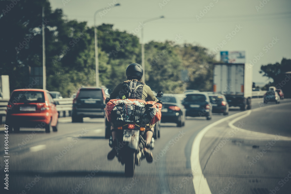 motorcycle traveler among traffic on the road
