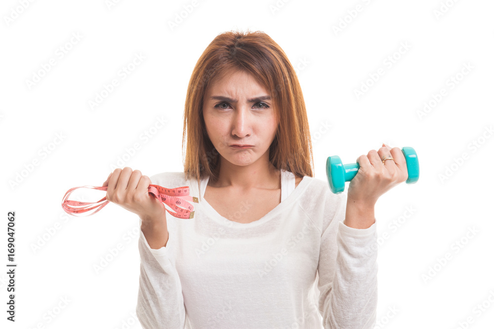 Exhausted Asian woman with dumbbells and measuring tape. Exhausted Asian woman with dumbbells and measuring tape.