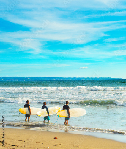 Group of surfers with surfb...