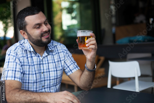 Handsome man drinking beer in bar