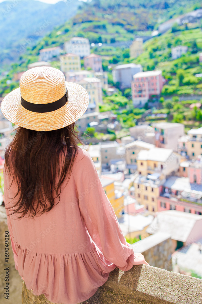 Beautiful woman with amazing view of the italian village in old street in Cinque Terre, Italy