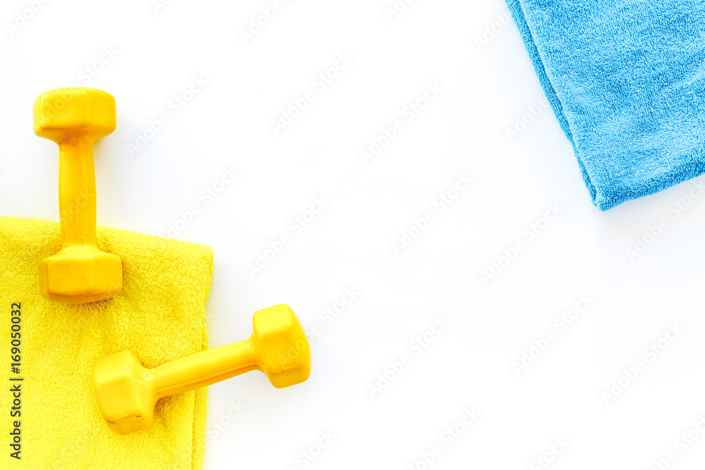 Fitness background. Dumbbells, towel and water on white background top view copyspace Fitness background. Dumbbells, towel and water on white background top view copyspace