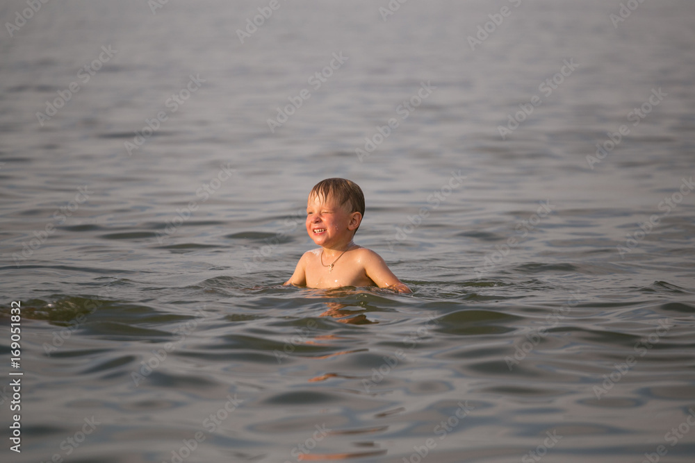 The boy is swimming in the sea.