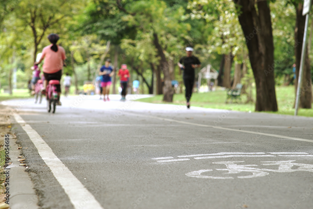 Crowd of people exercising, running and riding bicycle in the national park on a beautiful Sunday morning