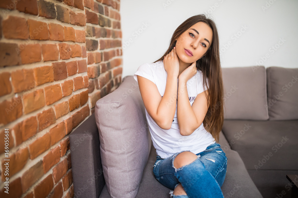 Happy young woman lying on couch and relaxing at home Happy young woman lying on couch and relaxing at home