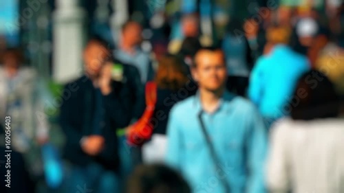 Wallpaper Mural Crowd of People / Commuters Walking / Busy Street. Anonymous crowd on a busy street. People talking cellphones walk down a busy street with green trees on a hot summer day. Slow motion. Torontodigital.ca