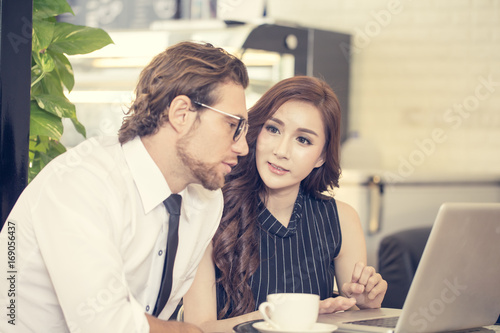 Smiling Attractive Asian woman with Businessman Talking for Business at cafe, Charming Young Woman Present for Business Plan, People Working Concept, Vintage Tone.