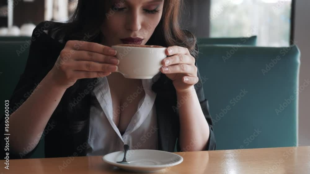 Young stylish business woman having a break at a cafe. She is sexy and sensual. Smiling. Dreaming. She flirts. Young stylish business woman having a break at a cafe. She is sexy and sensual. Smiling. Dreaming. She flirts.