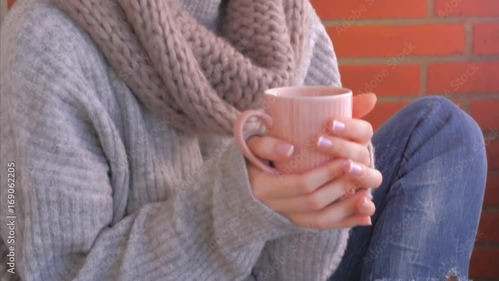 Woman relaxing and drinking hot Drink in Warm sweater. Cozy clothes Woman relaxing and drinking hot Drink in Warm sweater. Cozy clothes