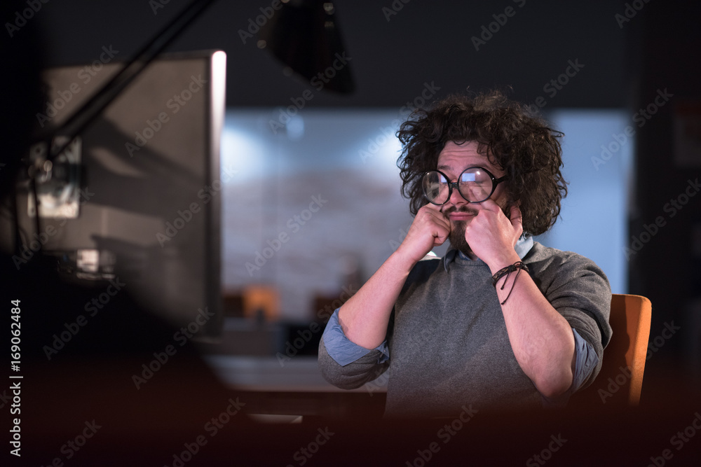 man working on computer in dark startup office