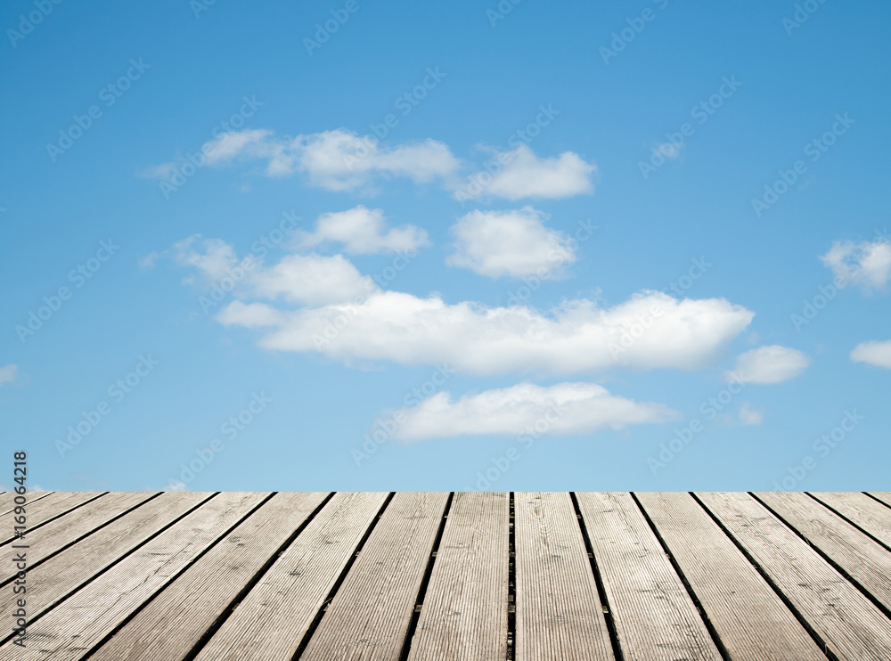 wooden floor against the sky with clouds