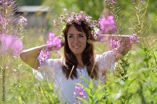 Brunette in white in summer tea willow field with wreath on head photo