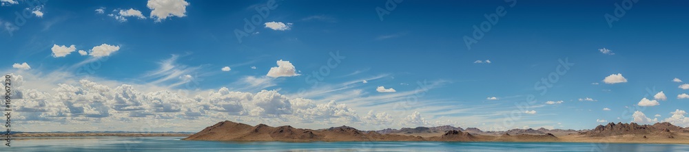 amazing fluffy white clouds in blue sky over ripple sea surface 
