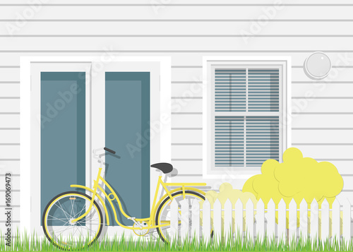 Detailed facade of the rural house with yellow bicycle.Front door of real estate