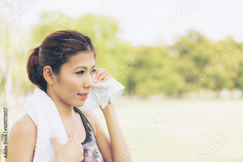 Beautiful woman relax after jogging and sweating after sport exercising at park