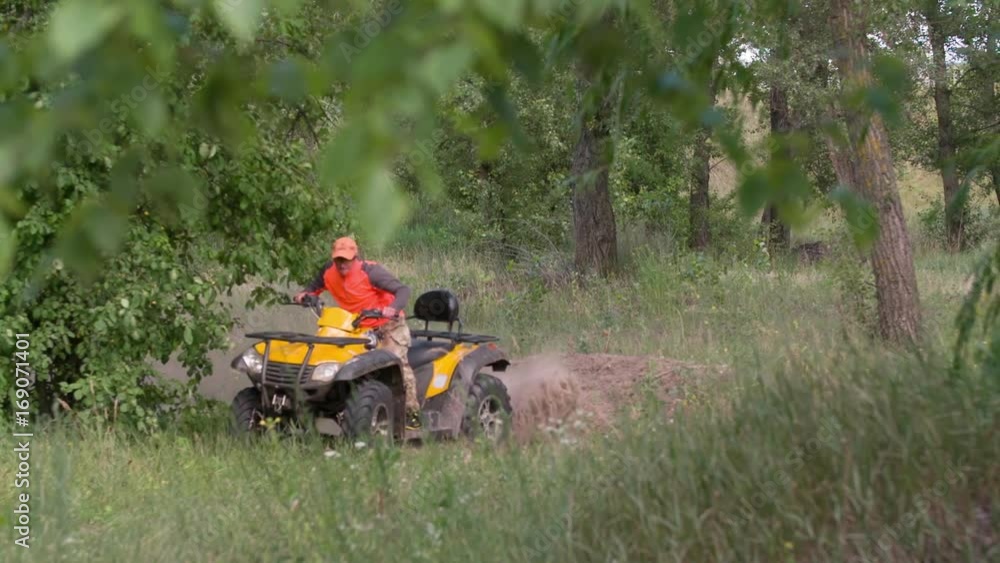 Man driving quad bike HD slow-motion video. All-terrain vehicle riding ATV in forest. Four-wheeler quadricycle transport and extreme sport. Man driving quad bike HD slow-motion video. All-terrain vehicle riding ATV in forest. Four-wheeler quadricycle transport and extreme sport.