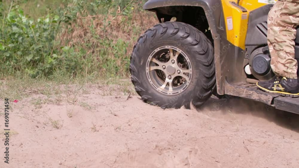 Man driving quad bike HD slow-motion video. Close-up of wheels. All-terrain vehicle riding ATV in forest. Four-wheeler quadricycle transport and extreme sport. Man driving quad bike HD slow-motion video. Close-up of wheels. All-terrain vehicle riding ATV in forest. Four-wheeler quadricycle transport and extreme sport.
