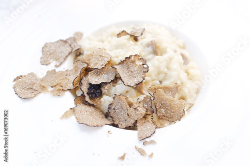 Risotto and black truffle serving in a white plate