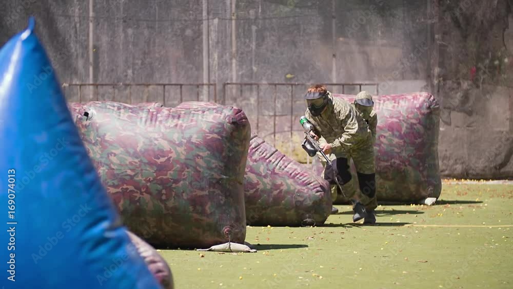 Paintball players aiming and shooting HD game slowmotion video. Man team with gun hitting on