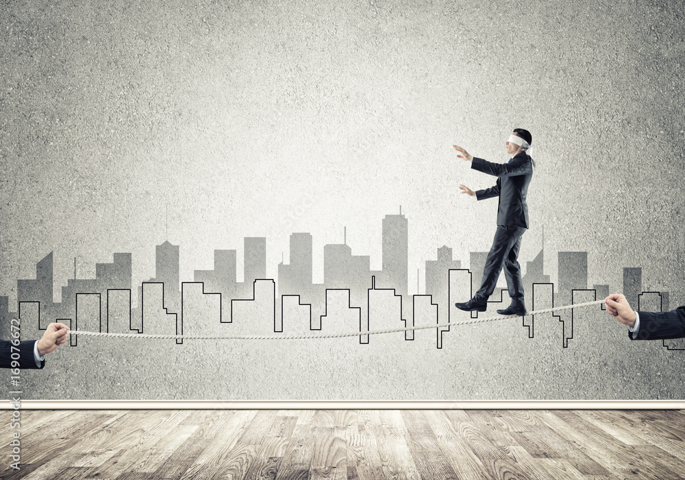 Business concept of risk support and assistance with man balancing on rope Business concept of risk support and assistance with man balancing on rope