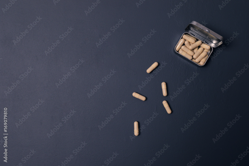 Pills in a metal box on a dark blue background. Medicines, the concept of health. Vitamins! Copy Space. Pills in a metal box on a dark blue background. Medicines, the concept of health. Vitamins! Copy Space.