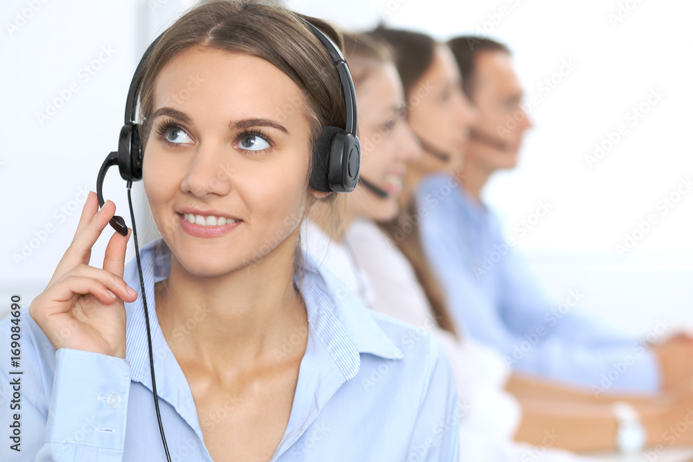 Call center operator in headset while consulting client. Telemarketing or phone sales. Customer service and business concept Call center operator in headset while consulting client. Telemarketing or phone sales. Customer service and business concept