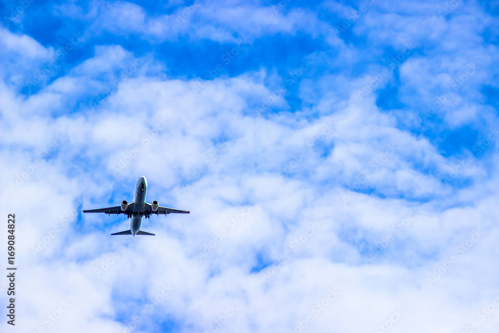 Fototapeta premium Airplane in the cloudy sky. Travel concept