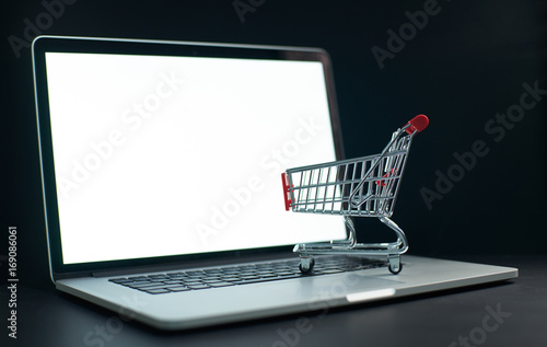 Shopping cart or trolley in front of Laptop , online marketing and business trading concept.