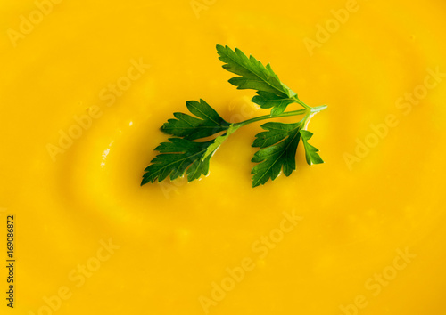 bright orange pumpkin soup with greens, macro © Nata Bene