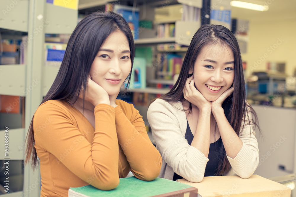 Woman in the foreground is reading a books. Young Asian Woman are reading in the modern library with Happy emotion. People with Education concept. Vintage Tone