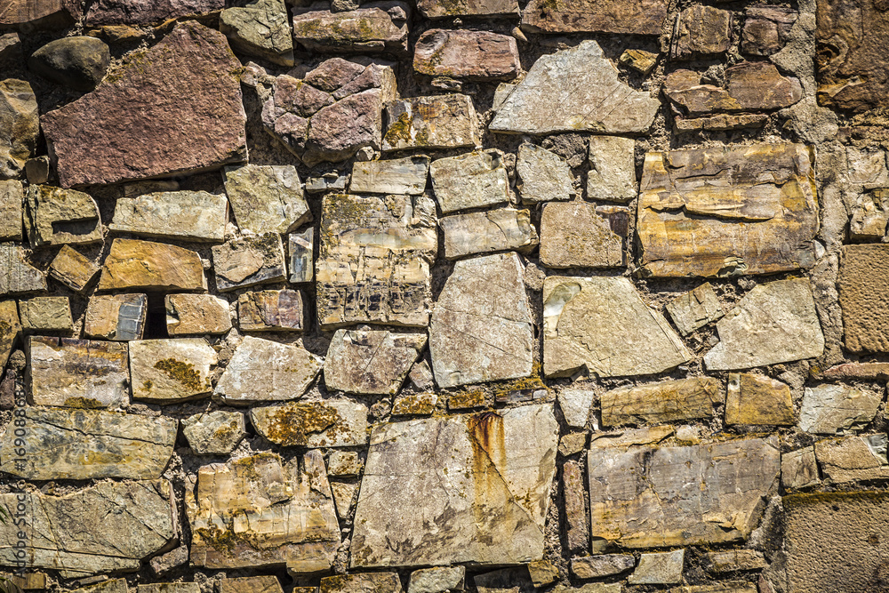 An old stone wall of an ancient fortress close up. An old stone wall of an ancient fortress close up.