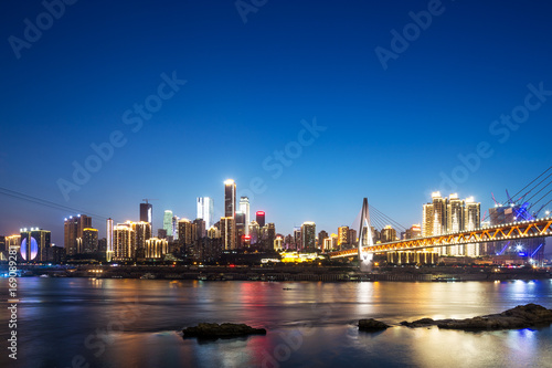 cityscape of modern city near water at twilight