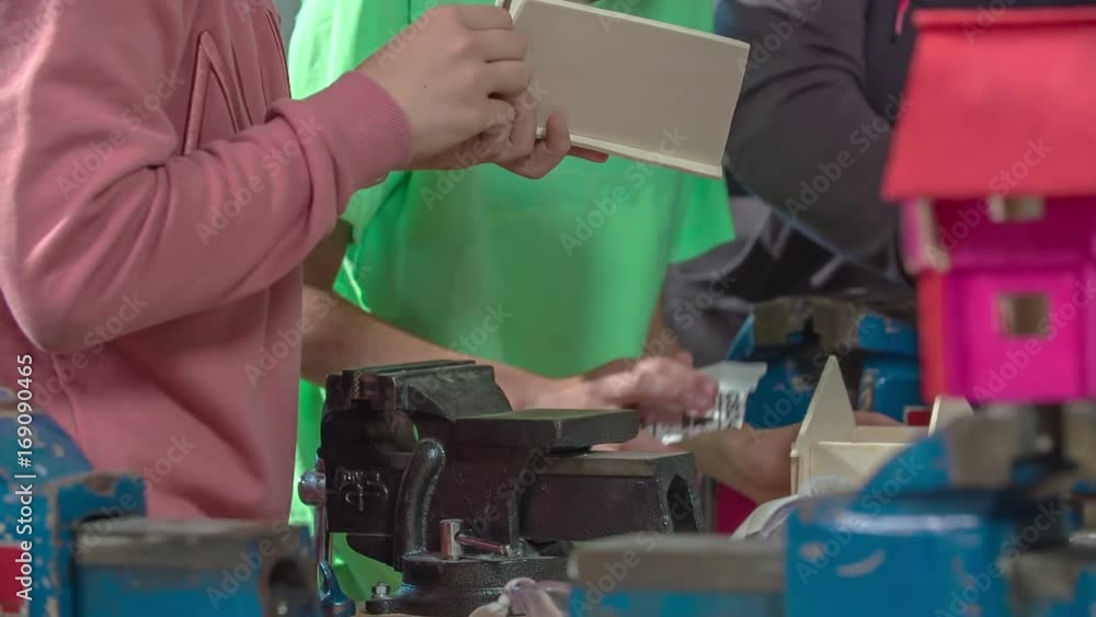 All students are busy chiselling wood and smaller parts of a wooden house. They are designing wooden houses together. All students are busy chiselling wood and smaller parts of a wooden house. They are designing wooden houses together.