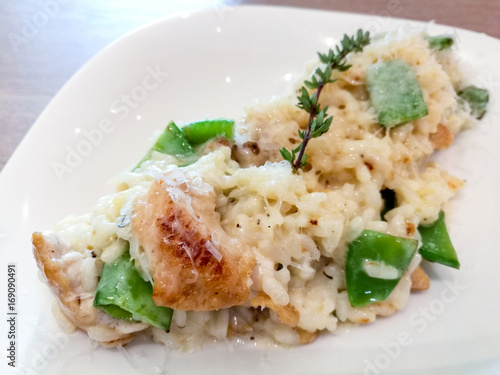 Tasty risotto with fresh herbs vegetables on a white plate