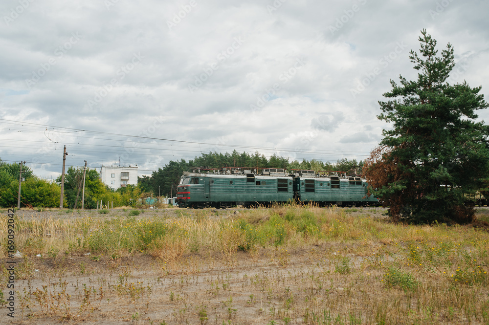 Train locomotive with wagons riding railroad in the forest. Low-speed railroad. Speed industrial post. Train locomotive with wagons riding railroad in the forest. Low-speed railroad. Speed industrial post.