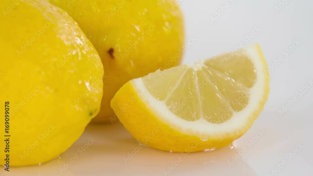 Fresh yellow lemons are lying on the table. One of them is cut. Fresh yellow lemons are lying on the table. One of them is cut.