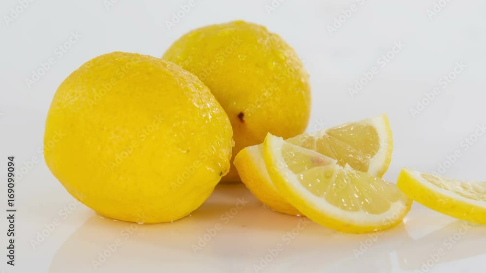 Pieces of lemon are falling down on a table. They look very fresh. Pieces of lemon are falling down on a table. They look very fresh.