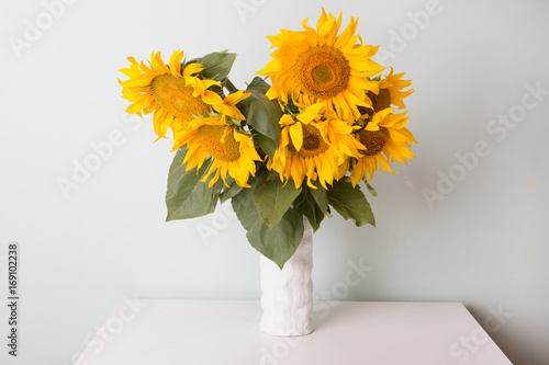 Wallpaper Mural Bouquet of sunflowers in old ceramic vase against a white  wall. Torontodigital.ca