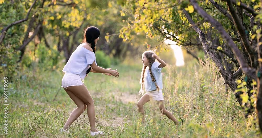 Child running into mother's hands to hug her. Family having fun in the park. Girl is happy to meet her mom. Slow motion Child running into mother's hands to hug her. Family having fun in the park. Girl is happy to meet her mom. Slow motion