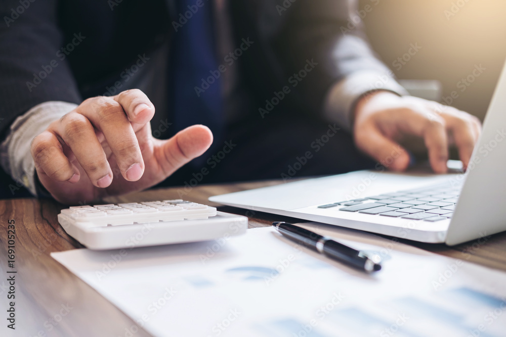 Professional businessman working with calculator, Doing finance on laptop, document graph and analysis business strategy to development profit Professional businessman working with calculator, Doing finance on laptop, document graph and analysis business strategy to development profit
